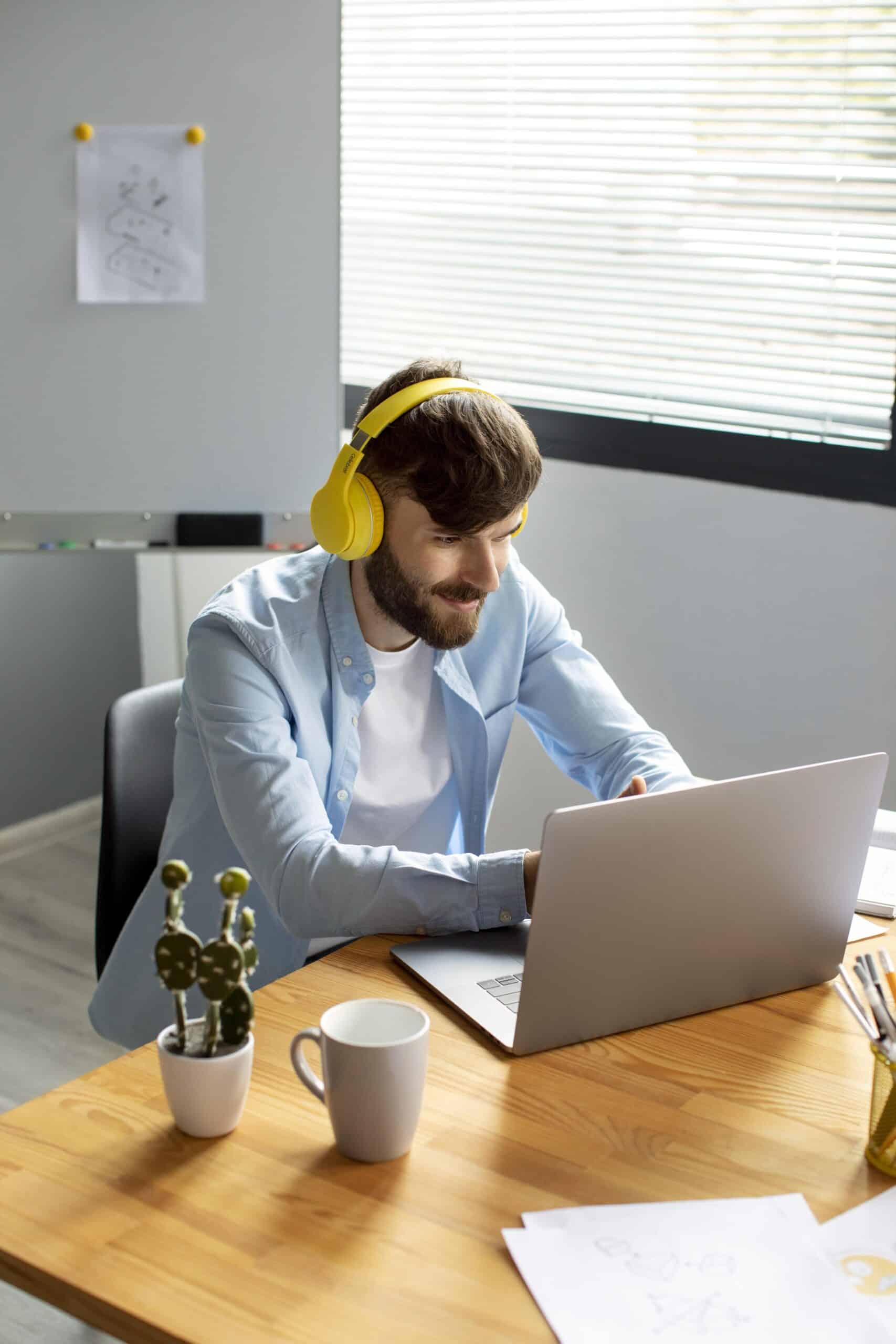 young-man-listening-music-headphones-while-working